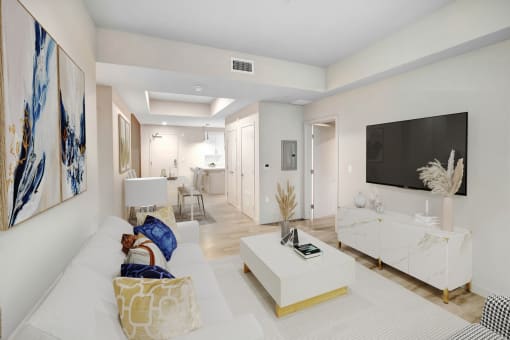 a living room with a white couch and a television