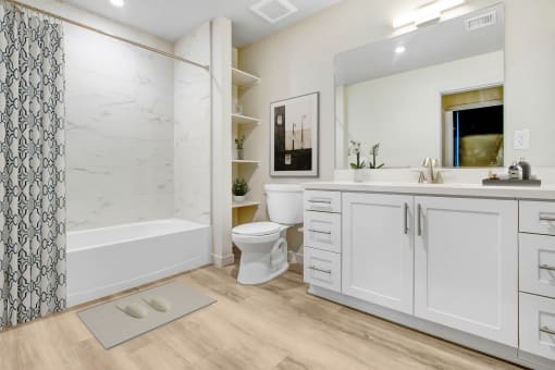 a bathroom with white cabinets and a shower and a toilet