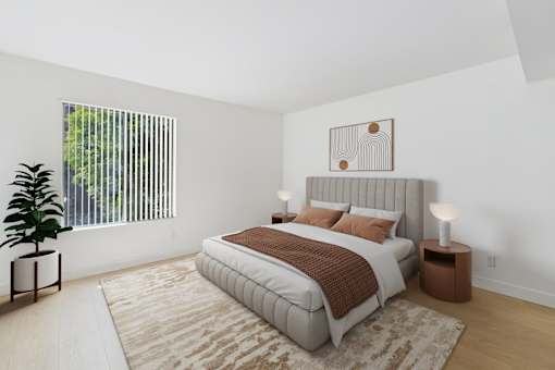 A bedroom with a large bed and a potted plant.