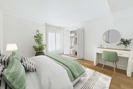 A bedroom with a bed, desk, and chair.