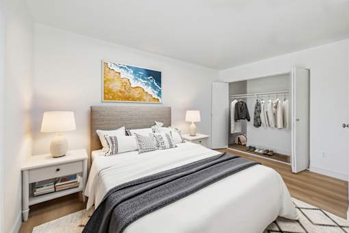 A bedroom with a large bed and a painting above it.
