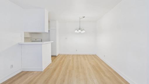 A white kitchen with a wooden floor and a white cabinet.