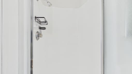 A white door with a silver handle and a small basket on the wall above it.