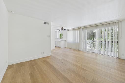 A room with wooden flooring and a window with blinds.