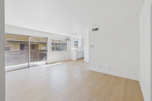 A large empty room with wooden floors and white walls.