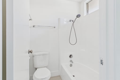 A white toilet is next to a white bathtub in a bathroom.