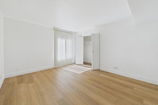 A room with wooden flooring and a sliding door.