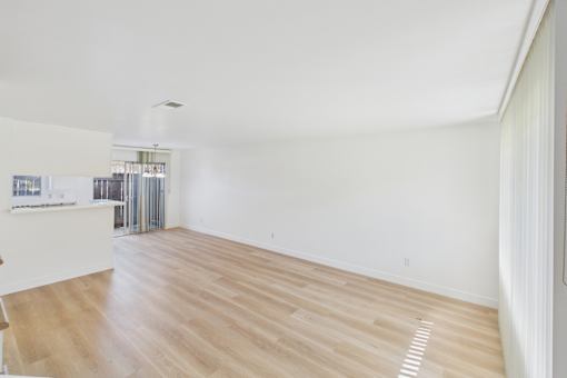 A room with wooden flooring and white walls.