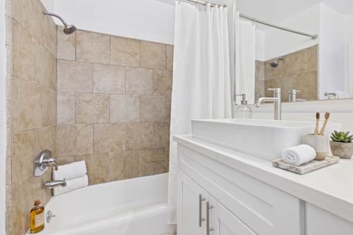 A white bathroom with a tiled shower and a white bathtub.