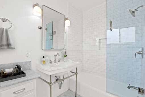 a white bathroom with a sink and a tub