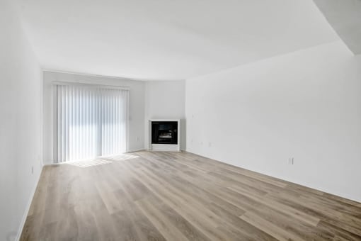 an empty living room with white walls and a fireplace