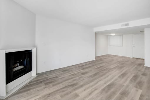 the living room and dining room of an apartment with a fireplace