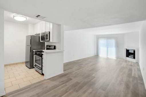 an empty room with a kitchen and a living room