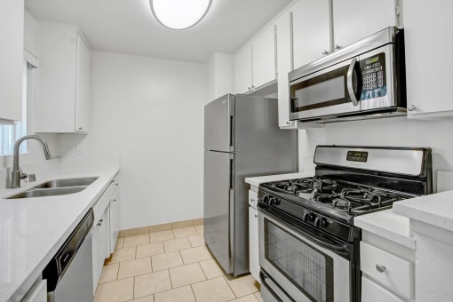 a kitchen with stainless steel appliances and white cabinets