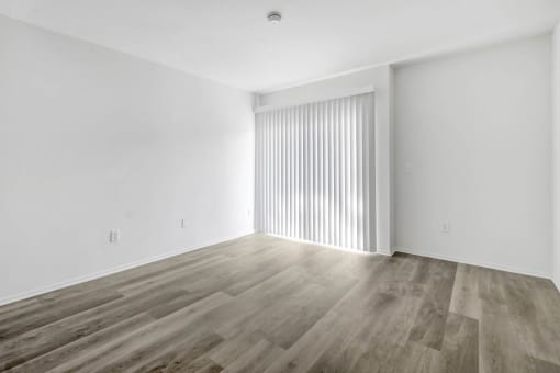 an empty living room with white walls and wood floors