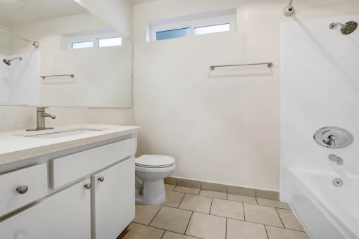 a bathroom with a toilet and a sink and a shower