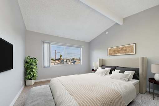 A bedroom with a large bed and a flat screen TV mounted on the wall.