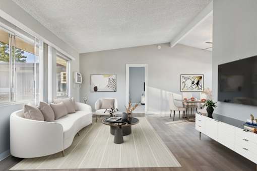 A modern living room with a white sofa and a coffee table.