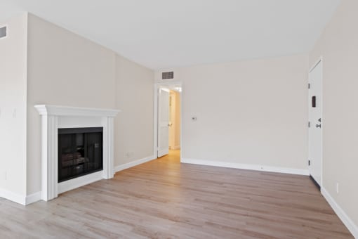 a bedroom with a fireplace and hardwood floors