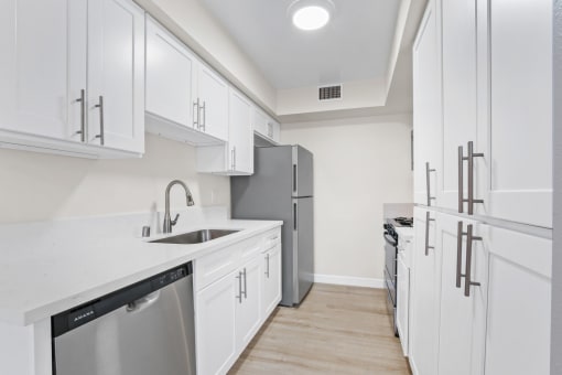 a kitchen with white cabinets and stainless steel appliances