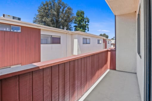 a balcony with a red fence and white buildings in the background