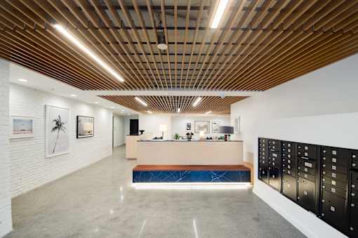 A reception area with a wooden ceiling and a white wall with a mailbox.