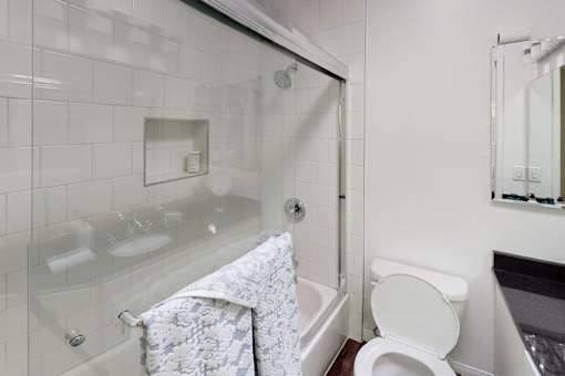 A white toilet sits next to a glass shower stall.