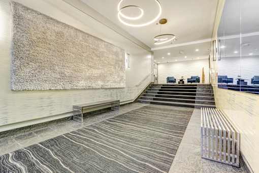 A long hallway with a bench and a staircase.
