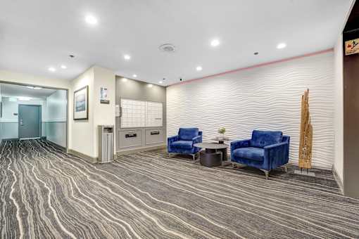 A waiting area with blue chairs and a wooden sculpture.