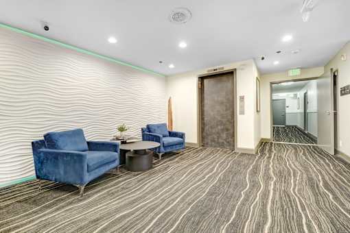 A room with blue chairs and a wooden door.