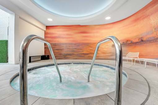 A hot tub in a room with a large mural on the wall.