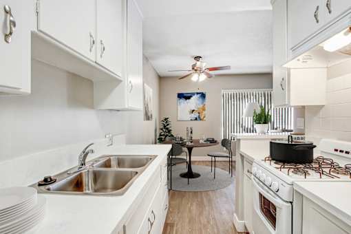 A kitchen with white cabinets and a black table.