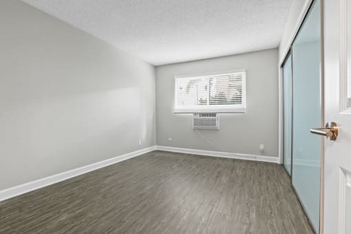 an empty room with a window and a door