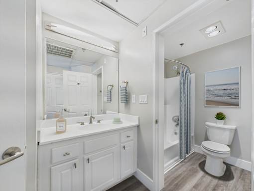 A white bathroom with a toilet, sink, and mirror.