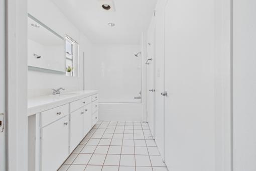 A white bathroom with a tiled floor and white walls.