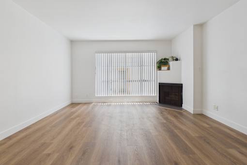 A room with a fireplace and a window with blinds.