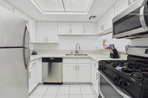 A modern kitchen with white cabinets and appliances.