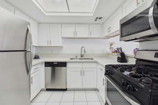 A modern kitchen with white cabinets and appliances.