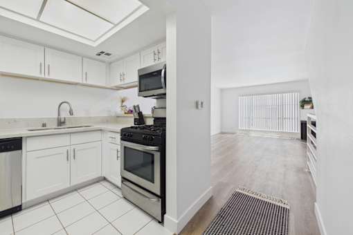 A kitchen with white cabinets and a black stove top oven.