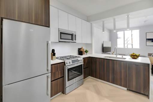 A modern kitchen with a stainless steel refrigerator and wooden cabinets.