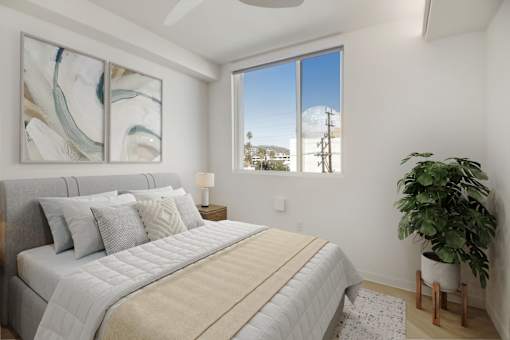 A bedroom with a large bed and a potted plant.