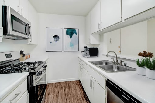 a kitchen with white cabinets and a sink and a microwave
