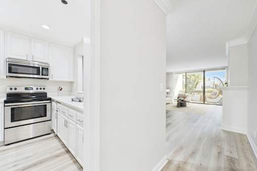 A modern kitchen with white cabinets and stainless steel appliances.