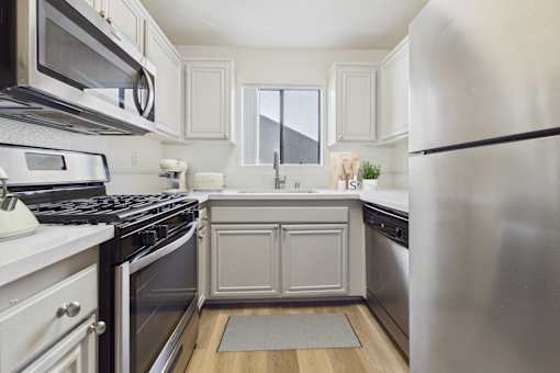 A modern kitchen with stainless steel appliances and white cabinetry.