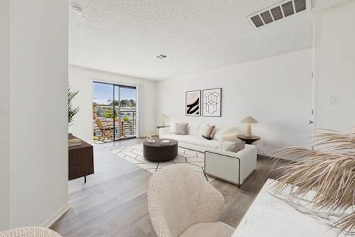 A living room with a white couch and a large window.