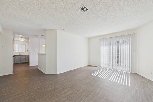 A room with wooden flooring and white walls.