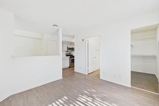 A white room with a wooden floor and a white door.