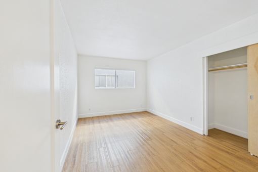 A room with wooden flooring and a window.