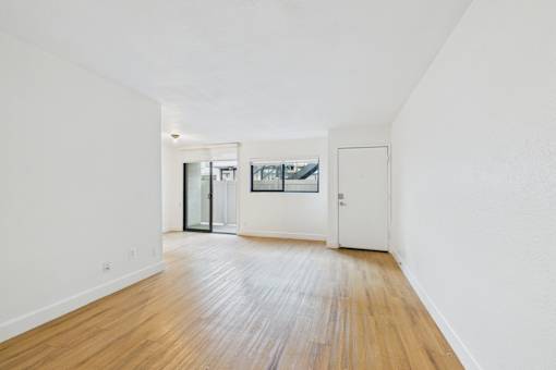 A room with a wooden floor and white walls.