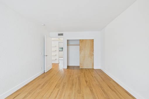 A room with a wooden floor and a white wall.